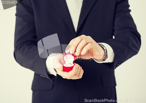 Image of man with gift box and wedding ring