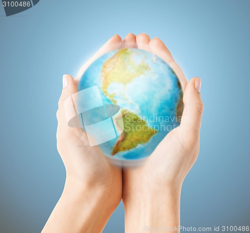 Image of close up of human hands with earth globe