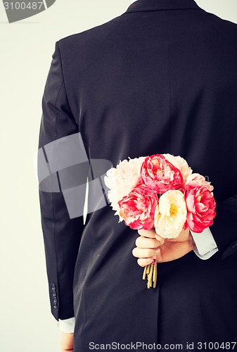 Image of man hiding bouquet of flowers