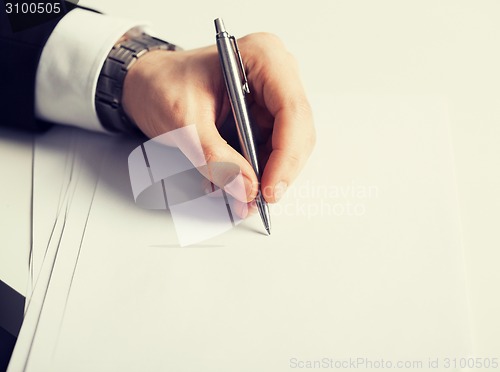 Image of businessman writing something on the paper