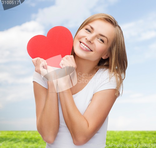 Image of smiling woman in white t-shirt holding red heart