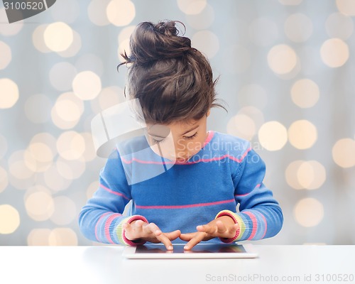 Image of little girl with tablet pc over lights background