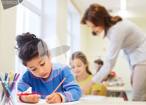 Image of happy school girl drawing with coloring pencils