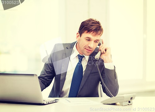 Image of businessman with laptop computer and phone