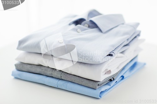 Image of close up of ironed and folded shirts on table