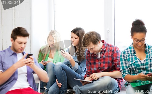 Image of students looking into devices at school