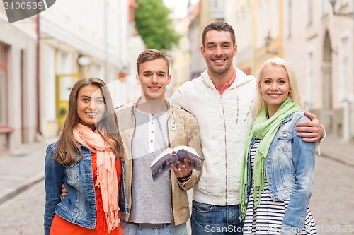 Image of group of friends with city guide exploring town