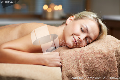 Image of young woman lying on massage table in spa