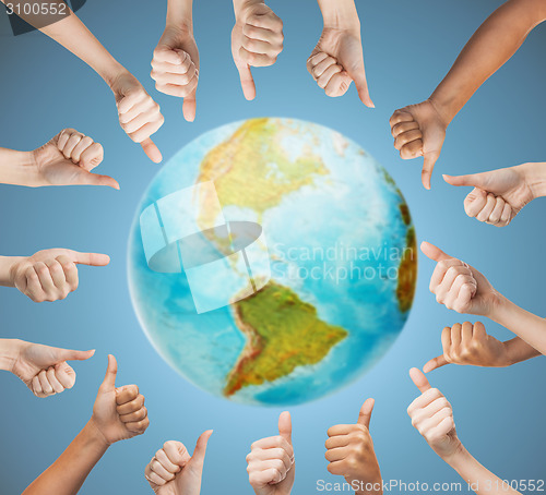 Image of human hands showing thumbs up in circle over earth