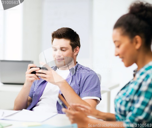 Image of students looking at devices at school