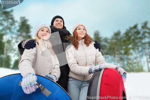 Image of group of smiling friends with snow tubes