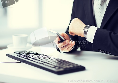 Image of man hands with keyboard, smartphone and wristwatch