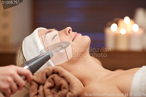Image of close up of young woman having face massage in spa