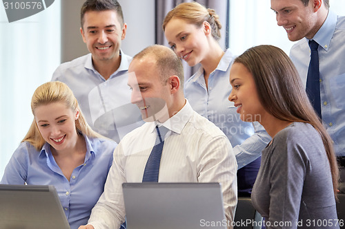 Image of smiling business people with laptop computer