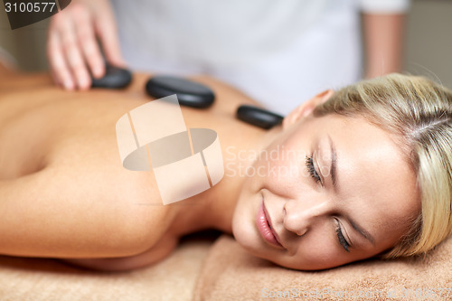 Image of close up of woman having hot stone massage in spa