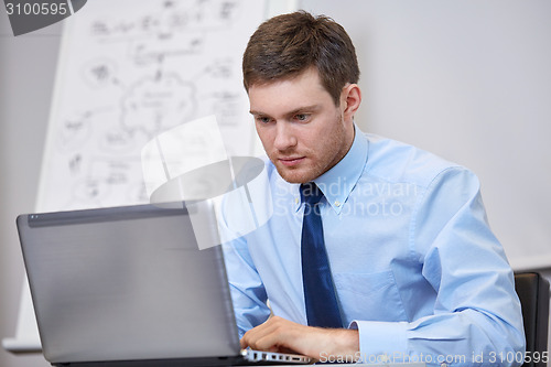Image of businessman sitting with laptop in office