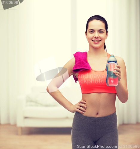 Image of sporty woman with towel and water bottle