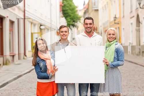 Image of group of smiling friends with blank white board