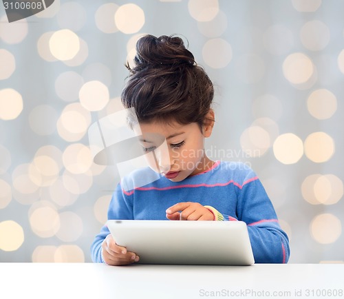 Image of little girl with tablet pc over lights background
