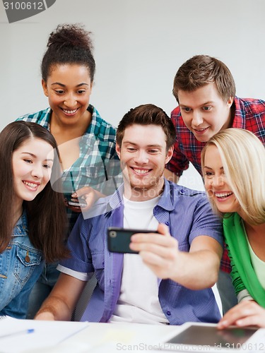 Image of students looking into smartphone at school