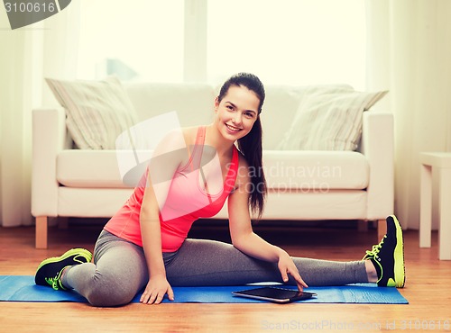 Image of smiling teenage girl streching on floor at home