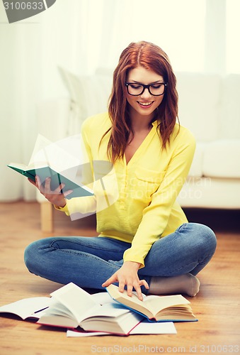 Image of smiling student girl reading books at home