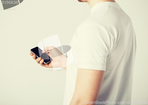 Image of man with smartphone typing something