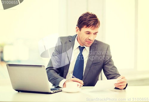 Image of businessman with laptop computer and documents