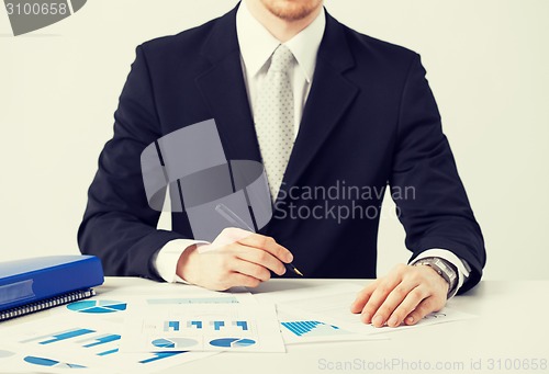 Image of businessman working and signing with papers