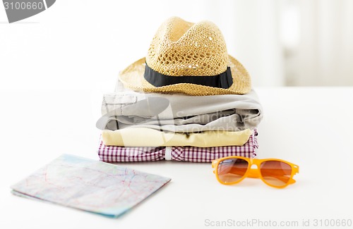 Image of close up of summer clothes and travel map on table
