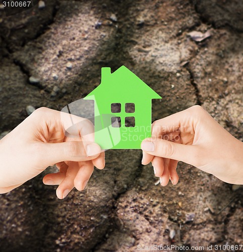 Image of close up of couple hands holding green house