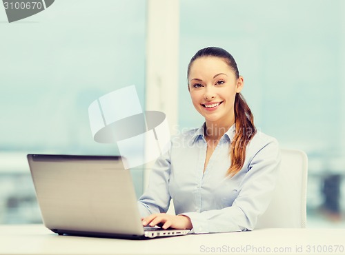 Image of businesswoman with laptop in office