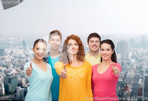 Image of group of smiling teenagers over city background