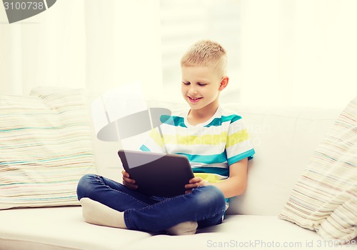 Image of smiling boy with tablet computer at home