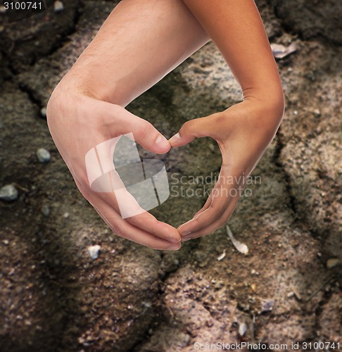 Image of woman and man hands showing heart shape