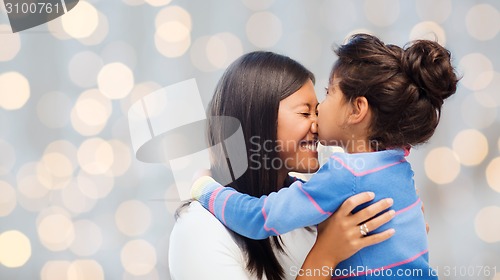 Image of happy little girl hugging and kissing her mother