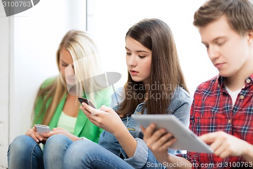 Image of students looking into devices at school