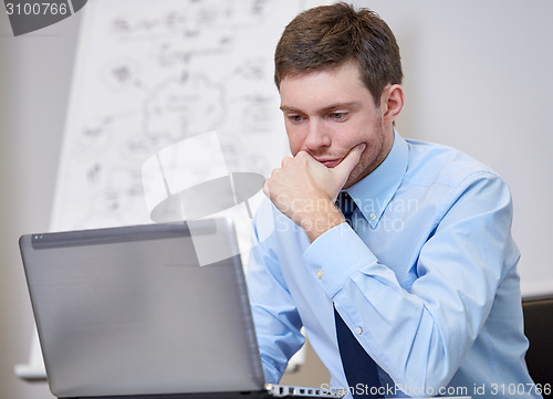 Image of businessman sitting with laptop in office