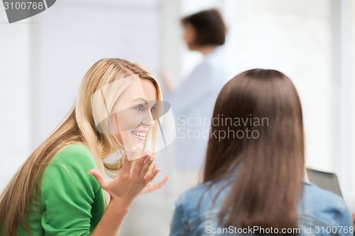 Image of student girl gossiping in lecture at school