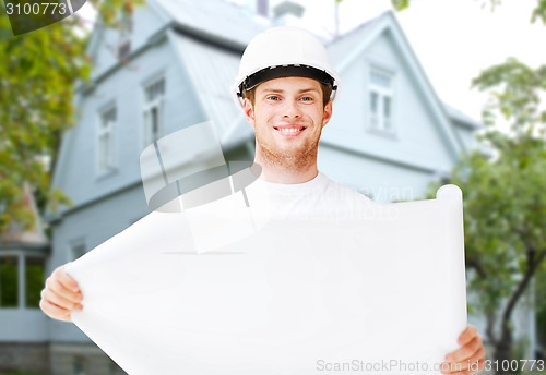 Image of male builder or architect in helmet with blueprint