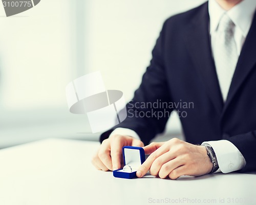 Image of man with gift box and wedding ring