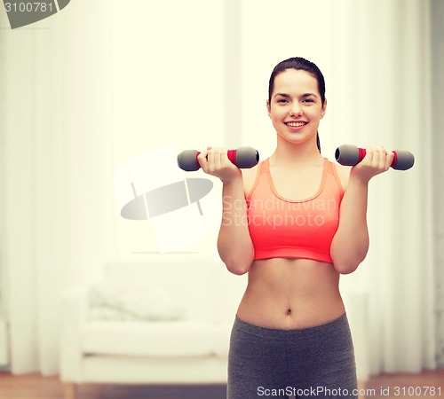 Image of young sporty woman with light dumbbells