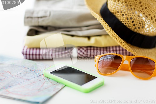 Image of close up of summer clothes and travel map on table