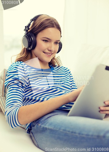 Image of girl with tablet pc and headphones at home