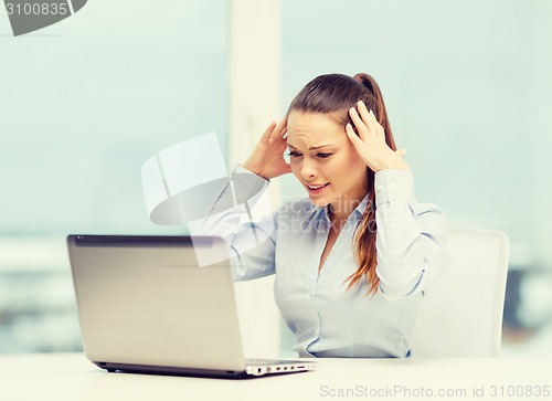 Image of stressed woman with laptop