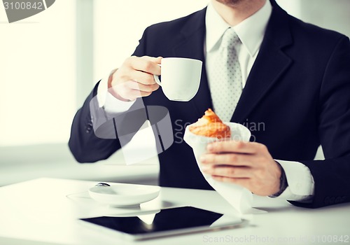 Image of man with tablet pc and cup of coffee