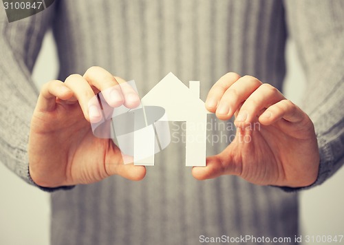 Image of man holding paper house