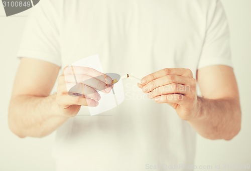 Image of man breaking the cigarette with hands