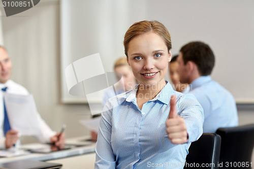 Image of group of smiling businesspeople meeting in office