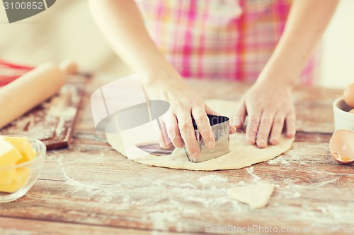 Image of close up of hands making cookies from fresh dough